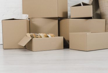 pile-cardboard-boxes-white-floor-min